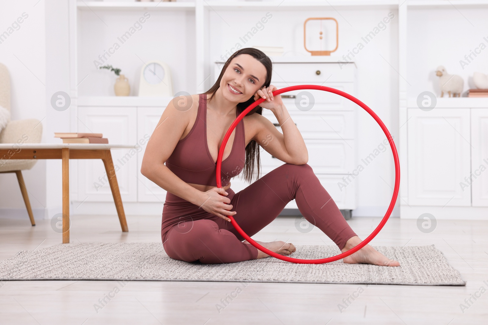 Photo of Smiling woman with hula hoop at home