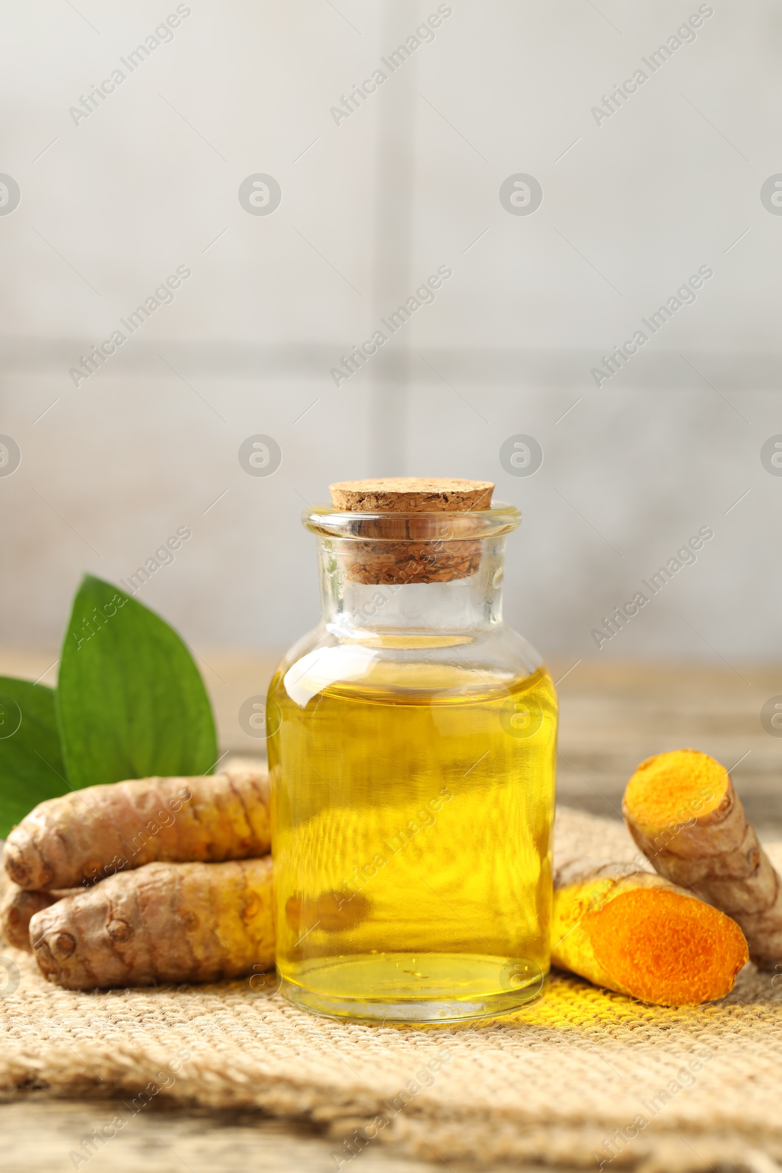 Photo of Tumeric oil and roots on table, closeup