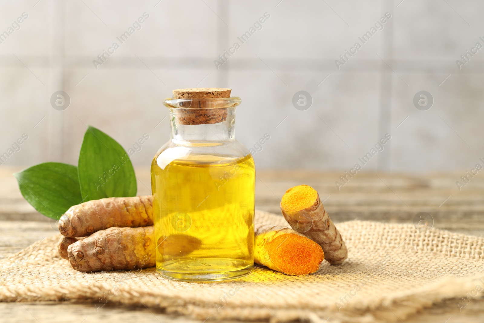 Photo of Tumeric oil and roots on table, closeup