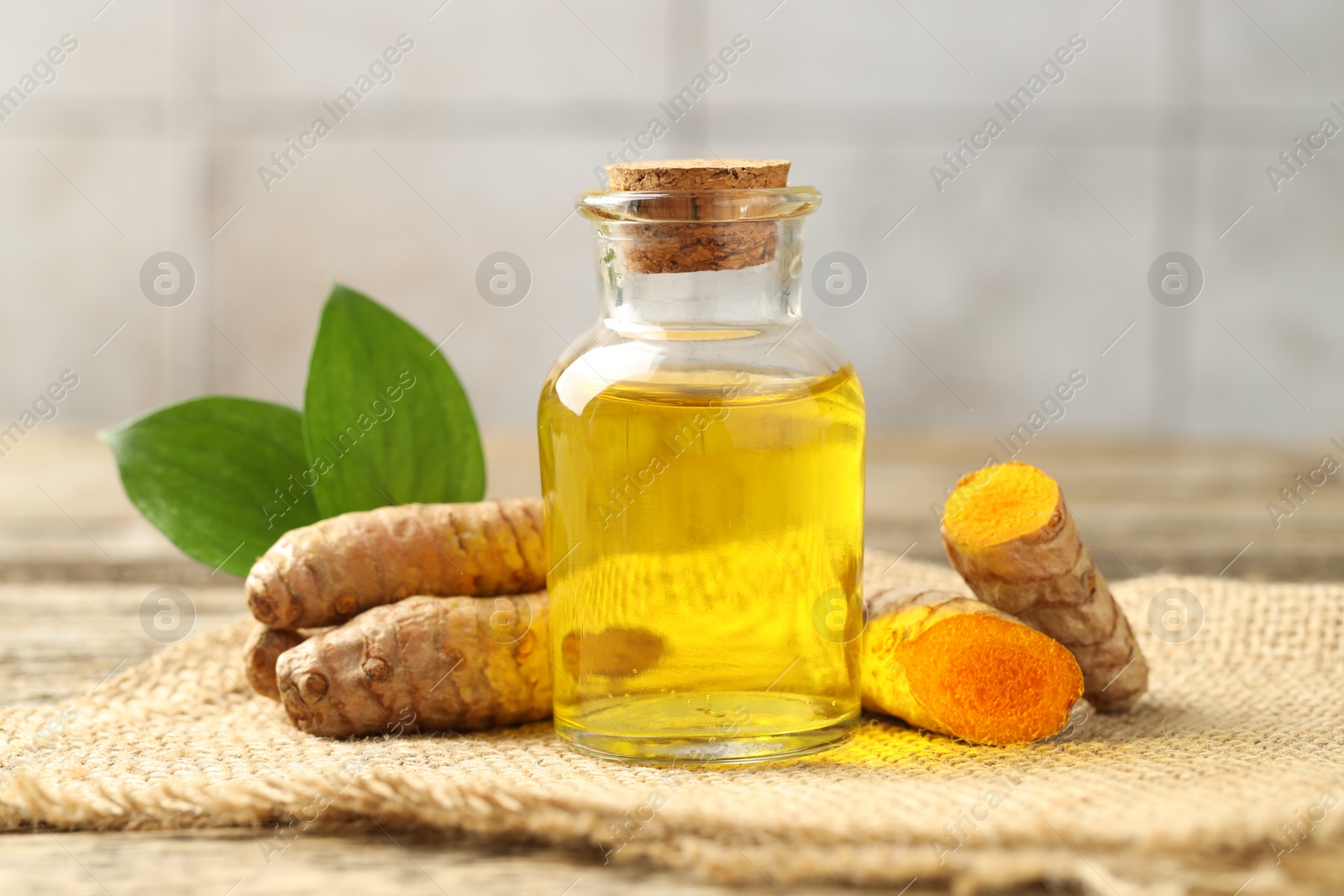 Photo of Tumeric oil and roots on table, closeup