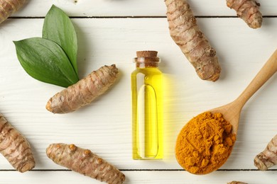 Photo of Tumeric oil, powder and roots on white wooden table, flat lay