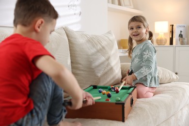 Photo of Cute brother and sister playing billiards at home