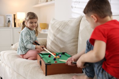 Photo of Cute brother and sister playing billiards at home