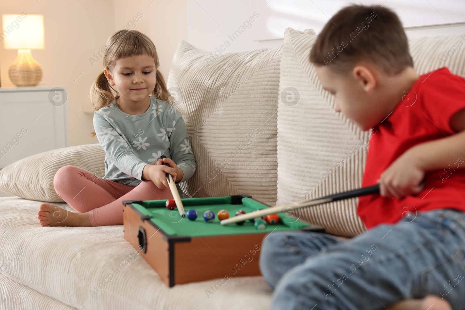 Photo of Cute brother and sister playing billiards at home