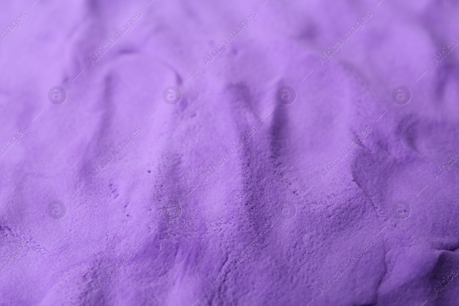 Photo of Bright purple play dough as background, closeup