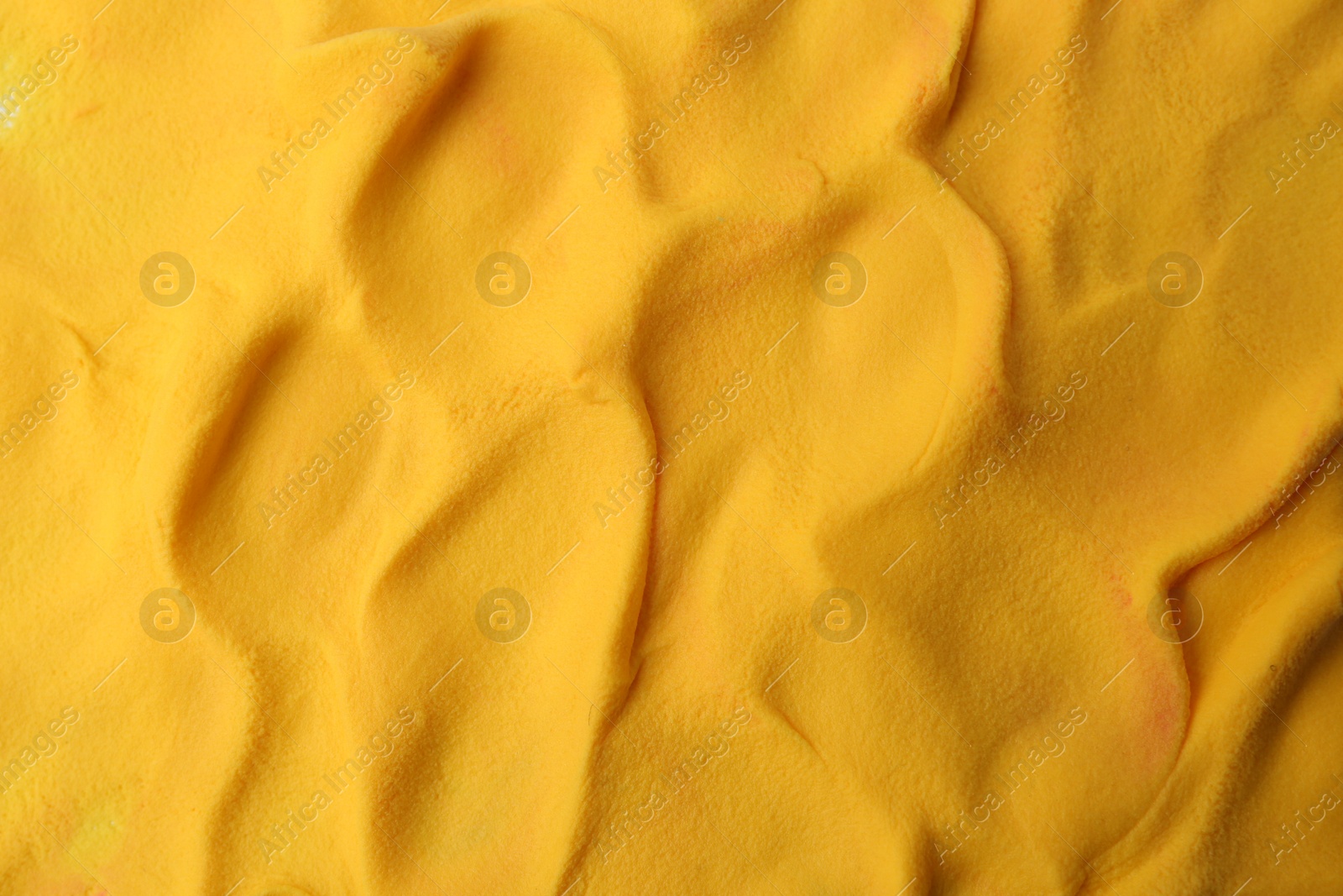 Photo of Yellow play dough as background, top view