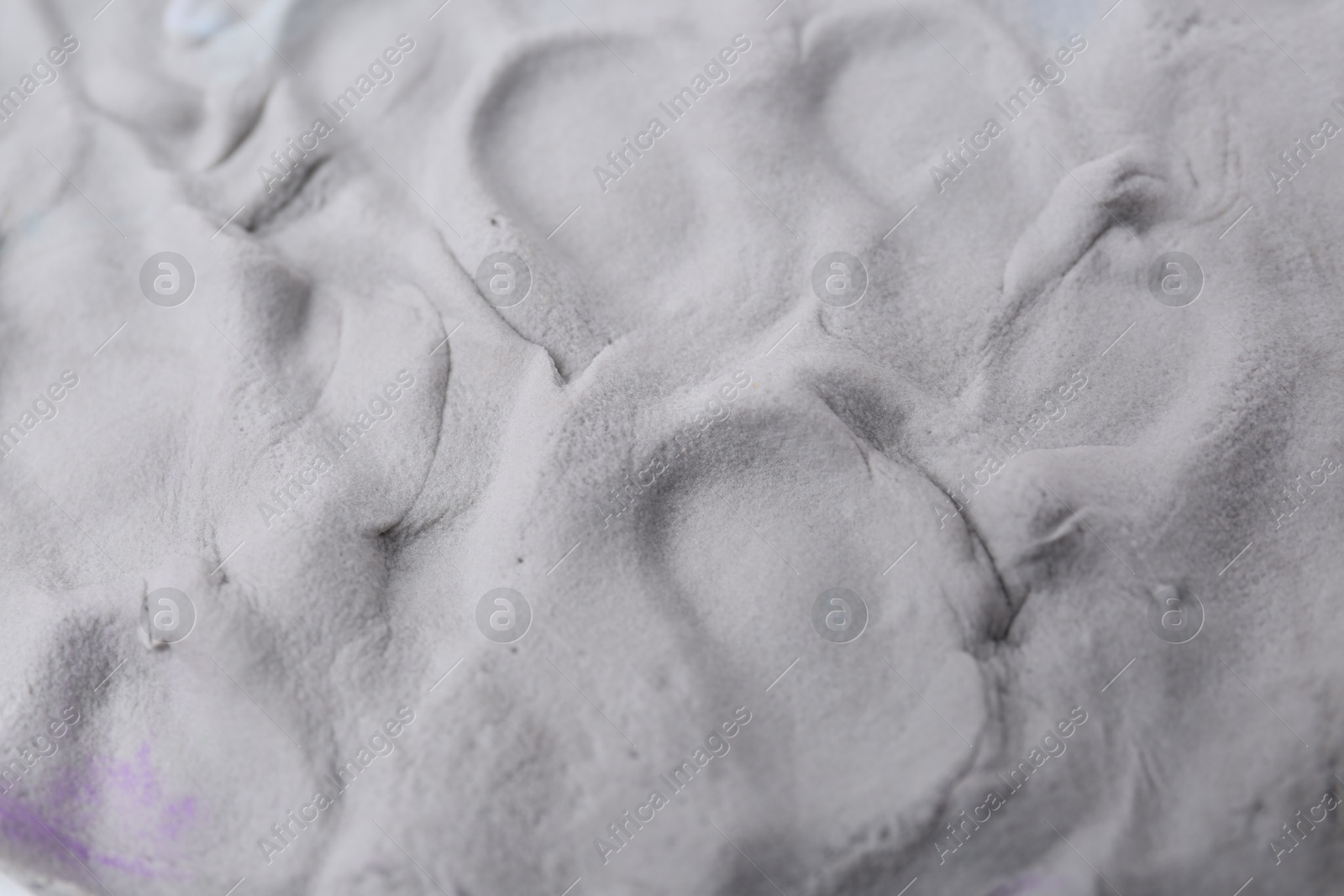 Photo of Grey play dough as background, closeup view