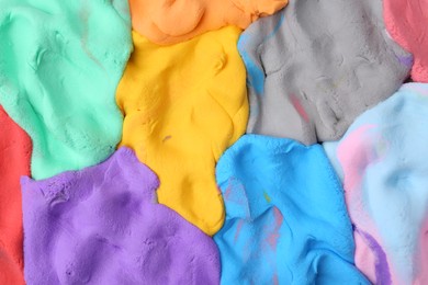 Photo of Different colorful play dough as background, top view