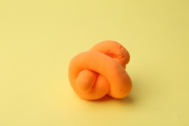 Photo of Bright orange play dough on yellow background