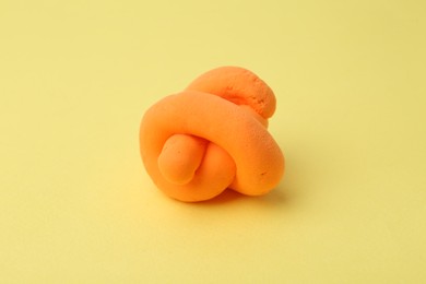 Photo of Bright orange play dough on yellow background