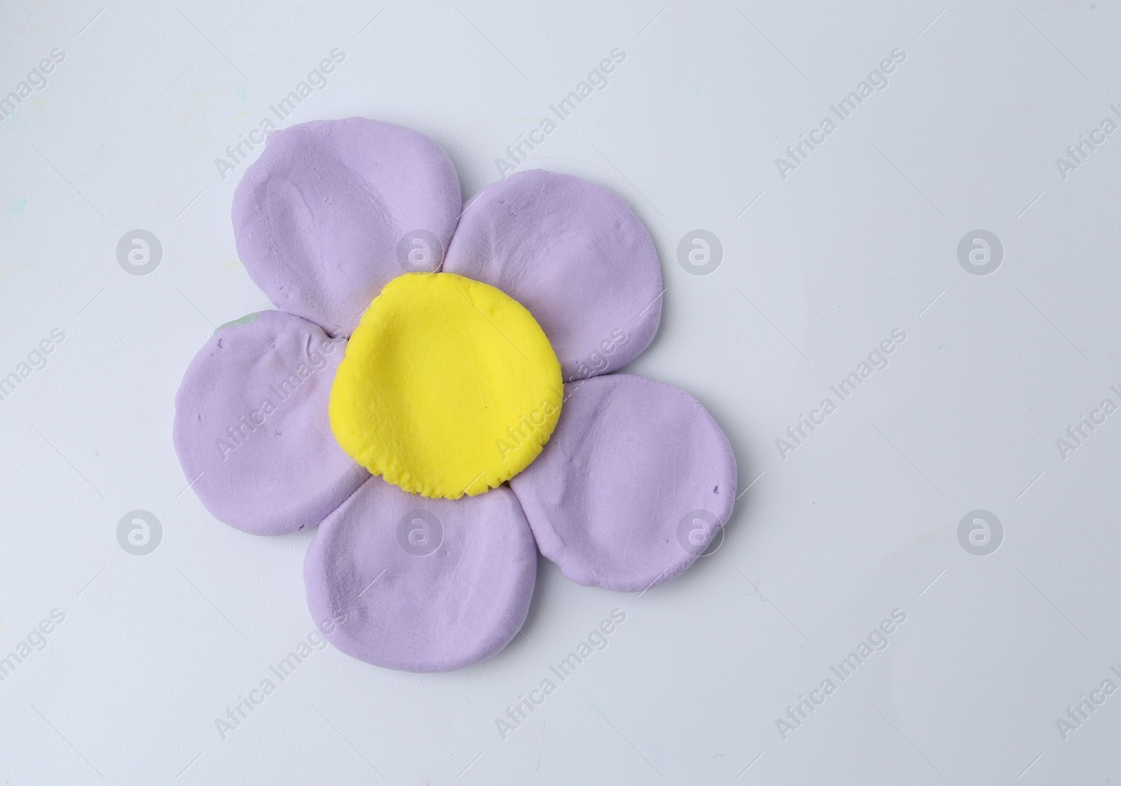 Photo of Flower made from play dough on light grey background, top view