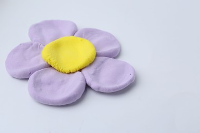 Photo of Flower made from play dough on light grey background, closeup. Space for text