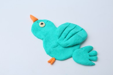 Photo of Bird made from play dough on grey background, closeup