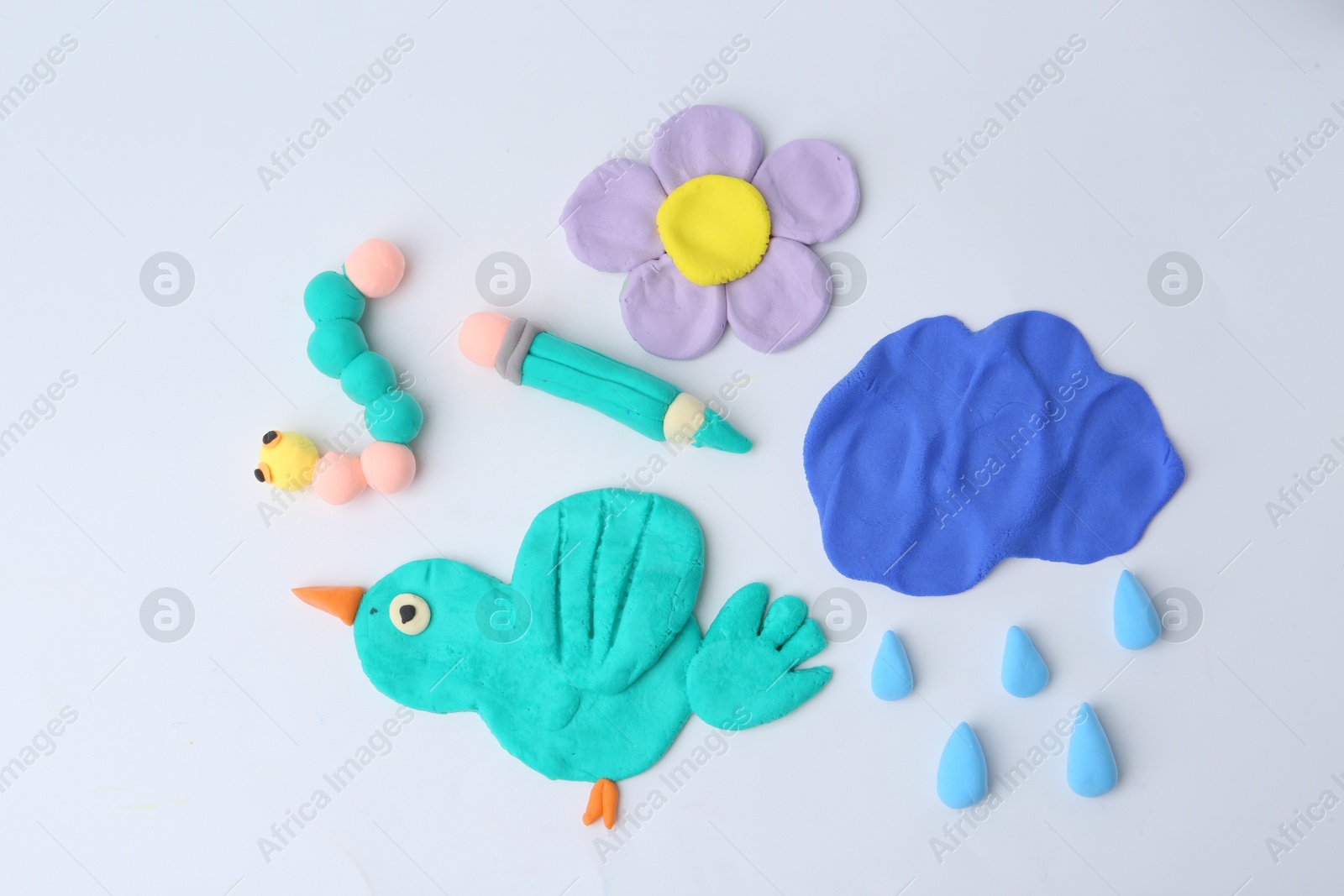 Photo of Different colorful child's crafts made of play dough on grey background, flat lay