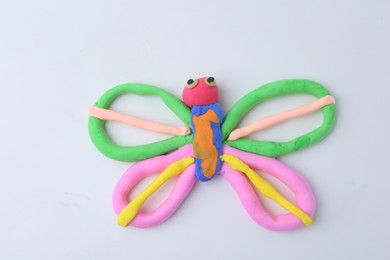 Photo of Butterfly made from play dough on white background, top view