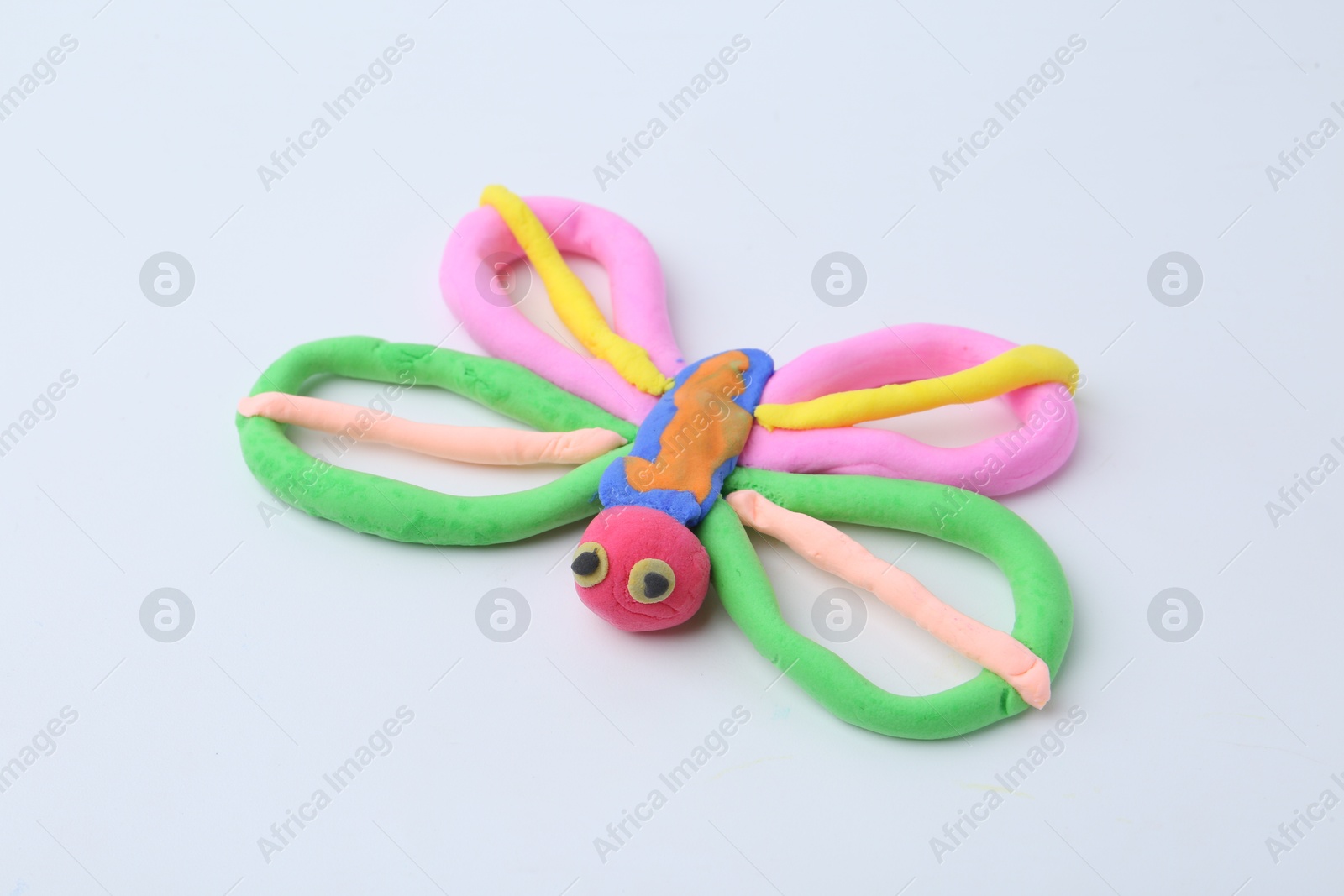 Photo of Butterfly made from play dough on white background, closeup