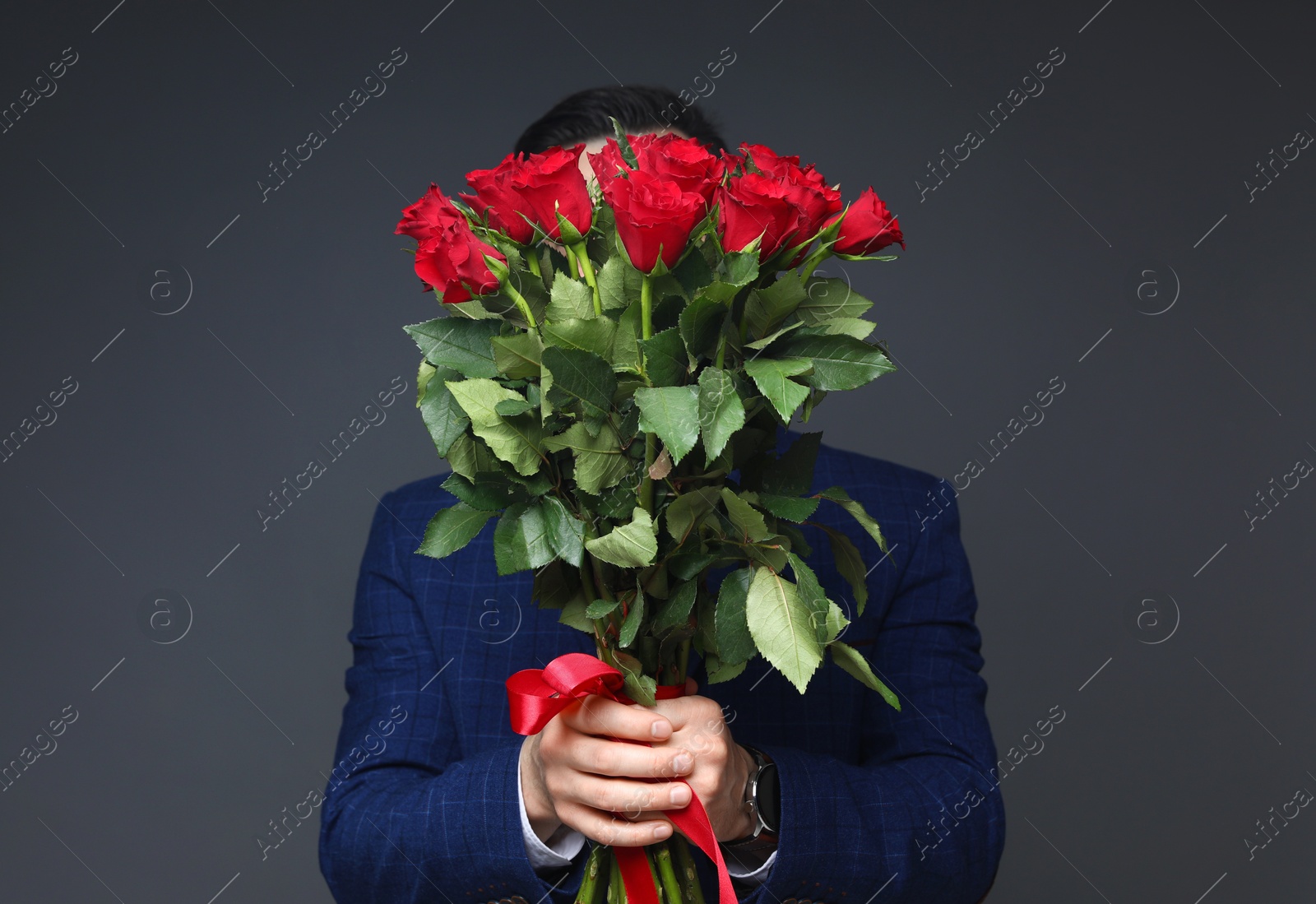 Photo of Happy Valentine's Day. Man with bouquet of roses on grey background