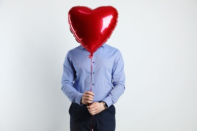 Photo of Happy Valentine's Day. Man with heart shaped balloon on white background