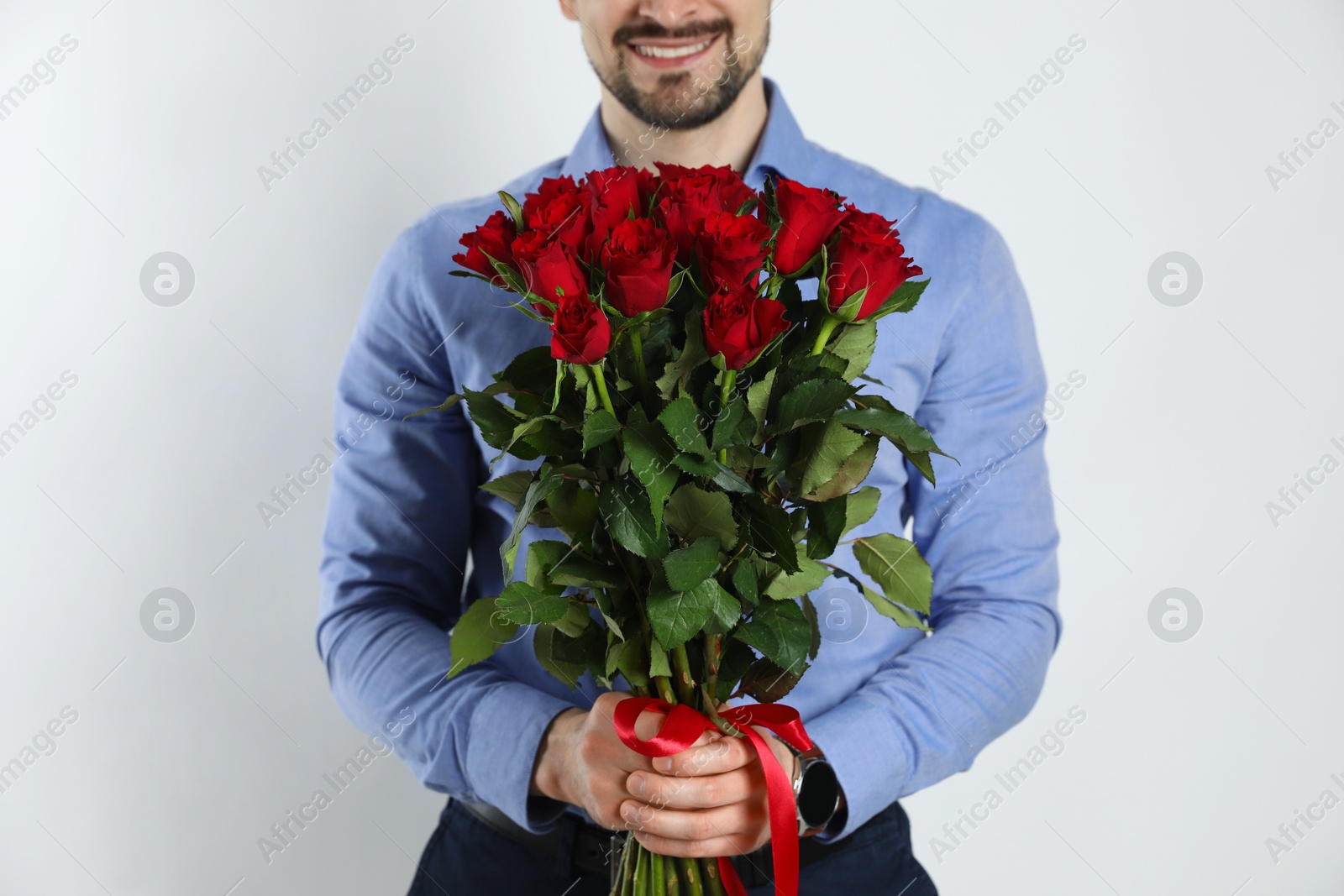 Photo of Happy Valentine's Day. Man with bouquet of roses on white background, closeup