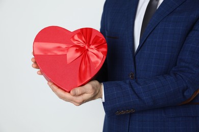 Photo of Happy Valentine's Day. Man with heart shaped gift box on white background, closeup