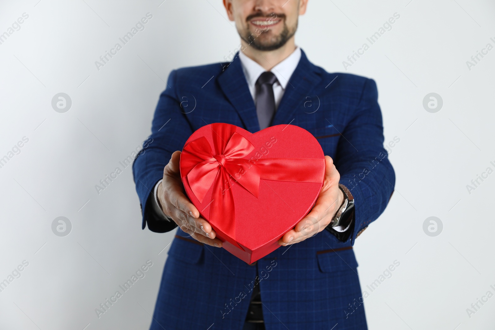 Photo of Happy Valentine's Day. Man with heart shaped gift box on white background, closeup