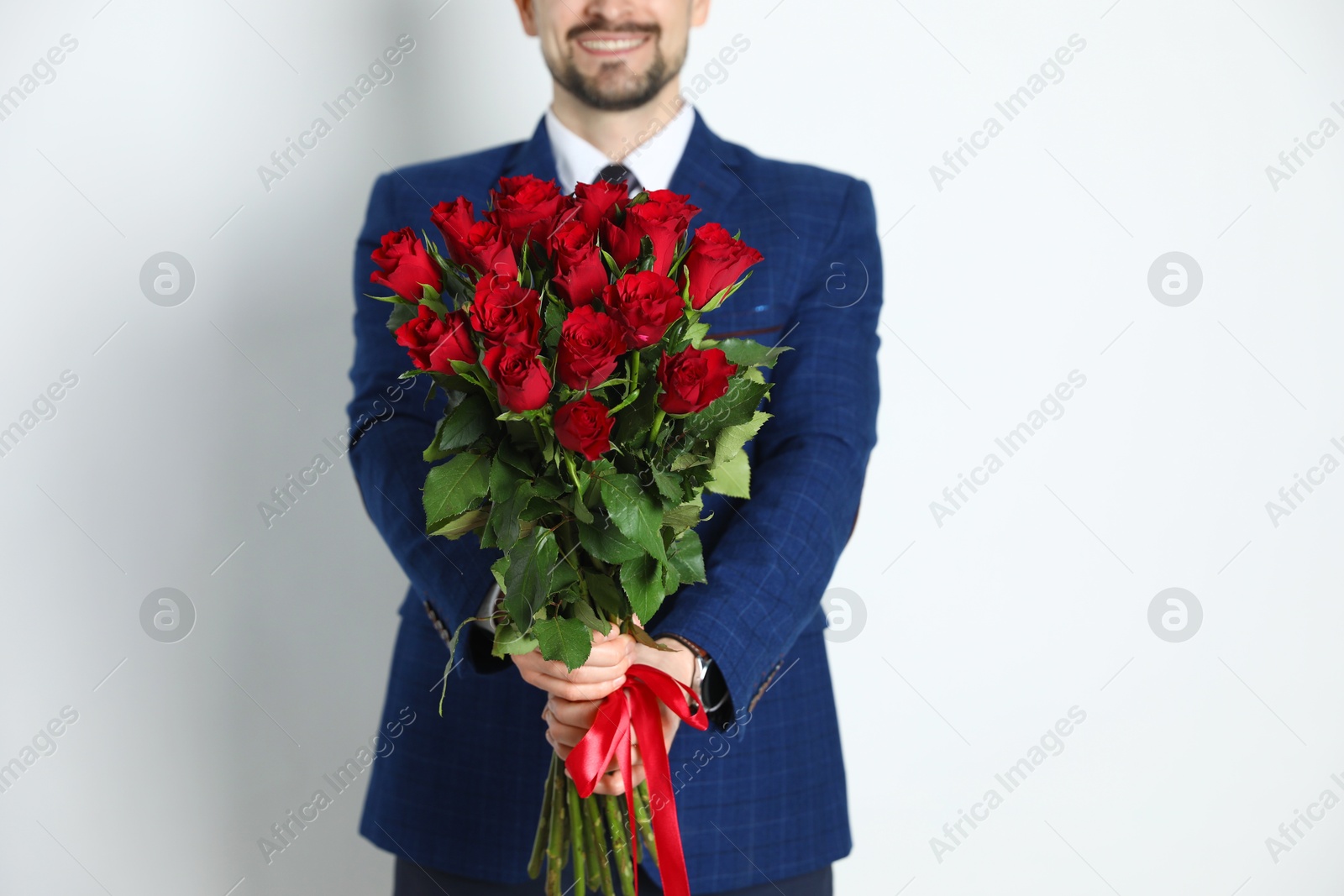 Photo of Happy Valentine's Day. Man with bouquet of roses on white background, closeup