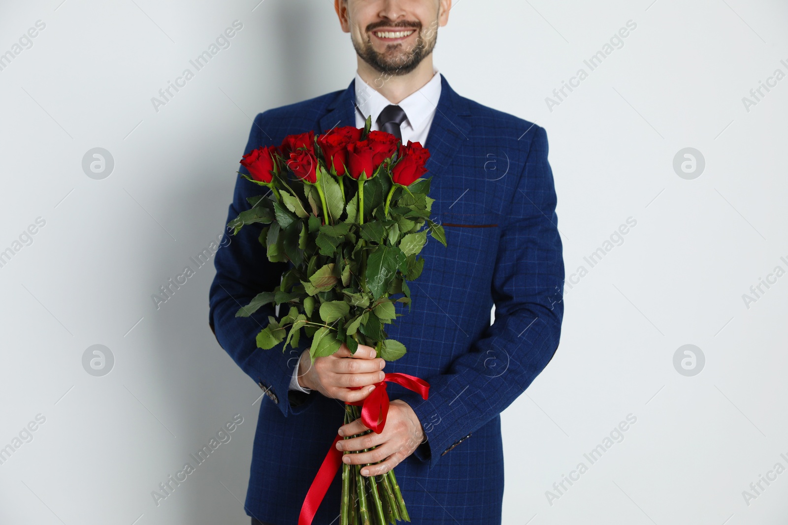 Photo of Happy Valentine's Day. Man with bouquet of roses on white background, closeup