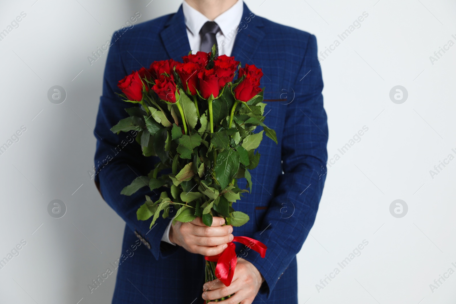 Photo of Happy Valentine's Day. Man with bouquet of roses on white background, closeup