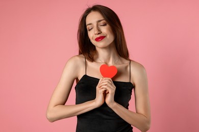 Photo of Happy Valentine's Day. Beautiful woman with paper heart on pink background