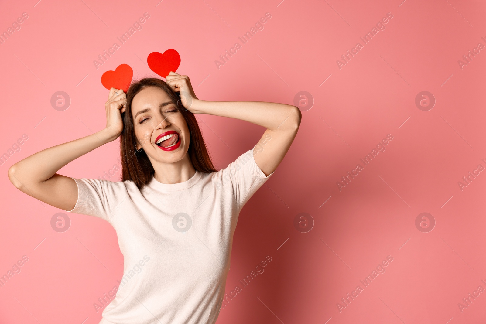 Photo of Happy Valentine's Day. Beautiful woman with paper hearts on pink background. Space for text