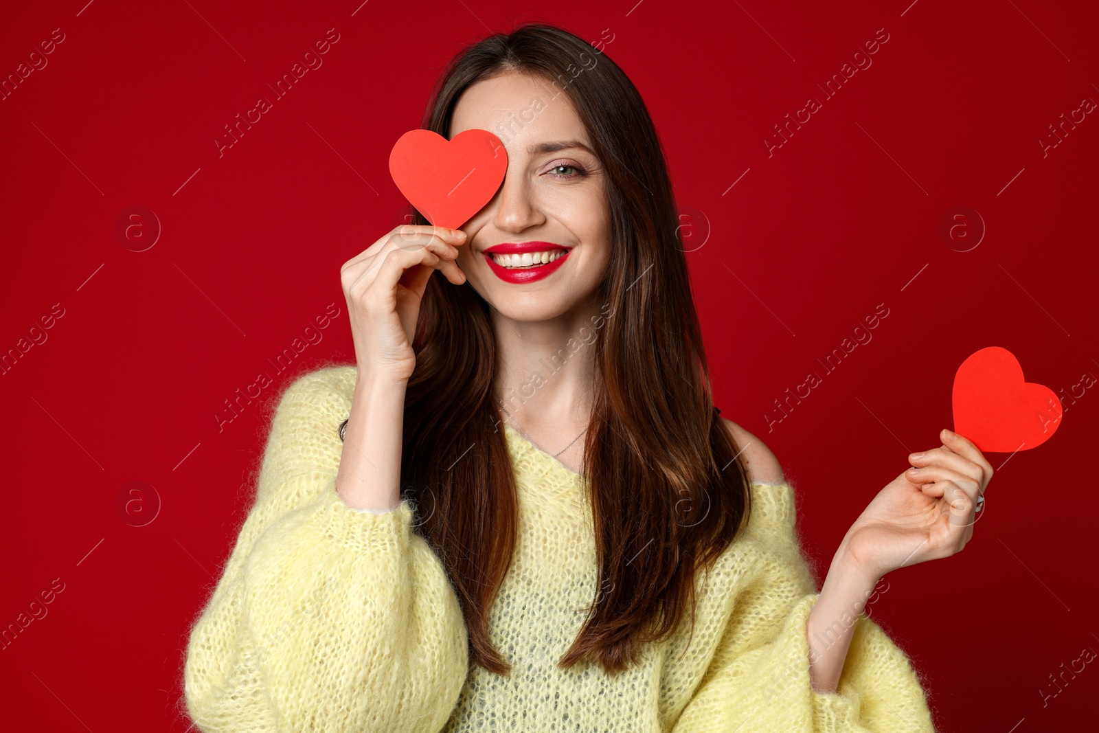 Photo of Happy Valentine's Day. Beautiful woman with paper hearts on red background