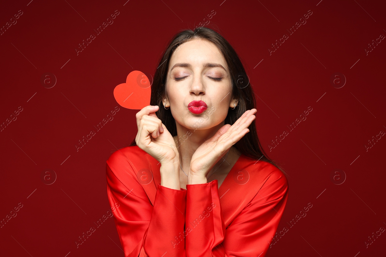 Photo of Happy Valentine's Day. Beautiful woman with paper heart on red background