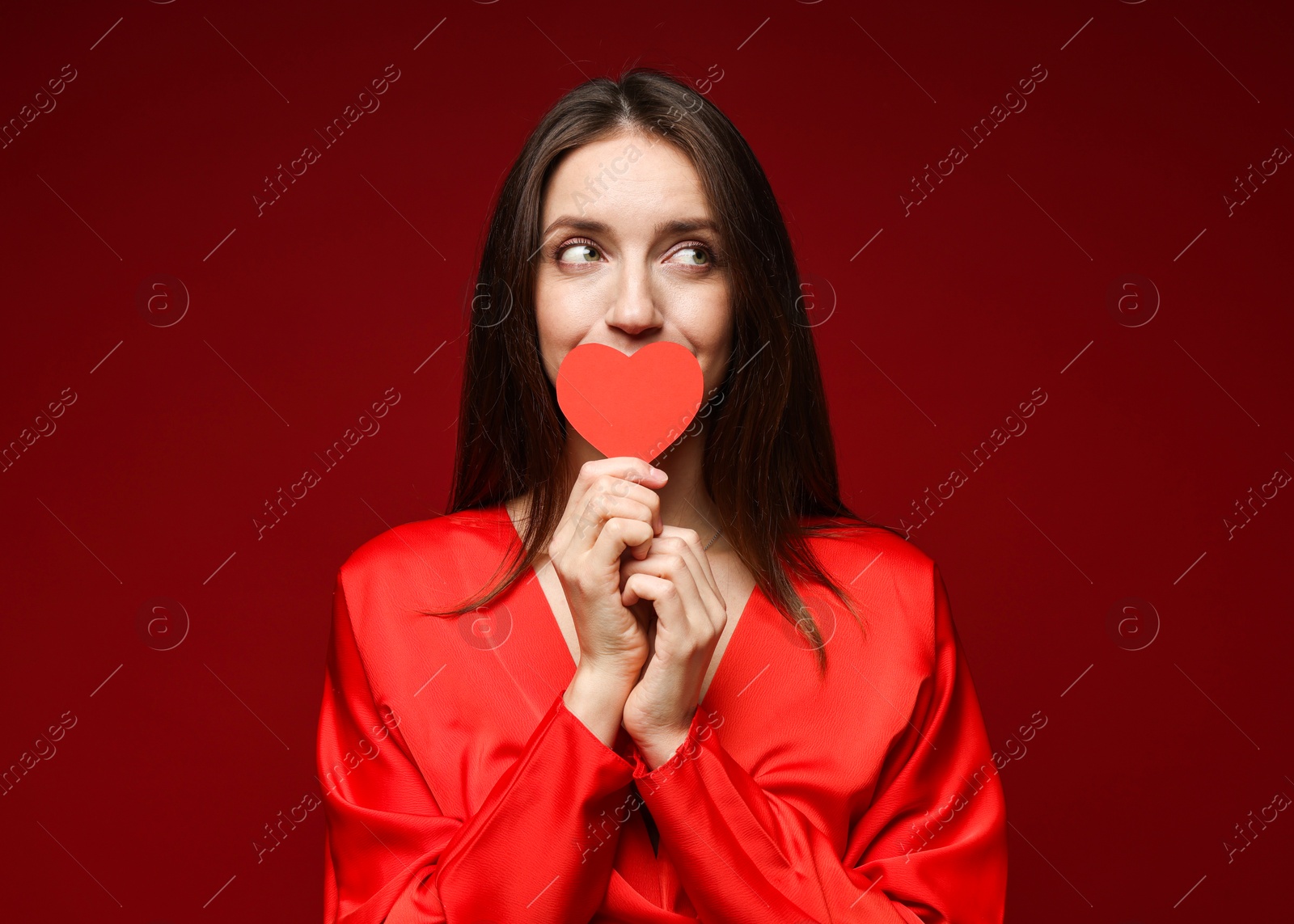 Photo of Happy Valentine's Day. Beautiful woman with paper heart on red background