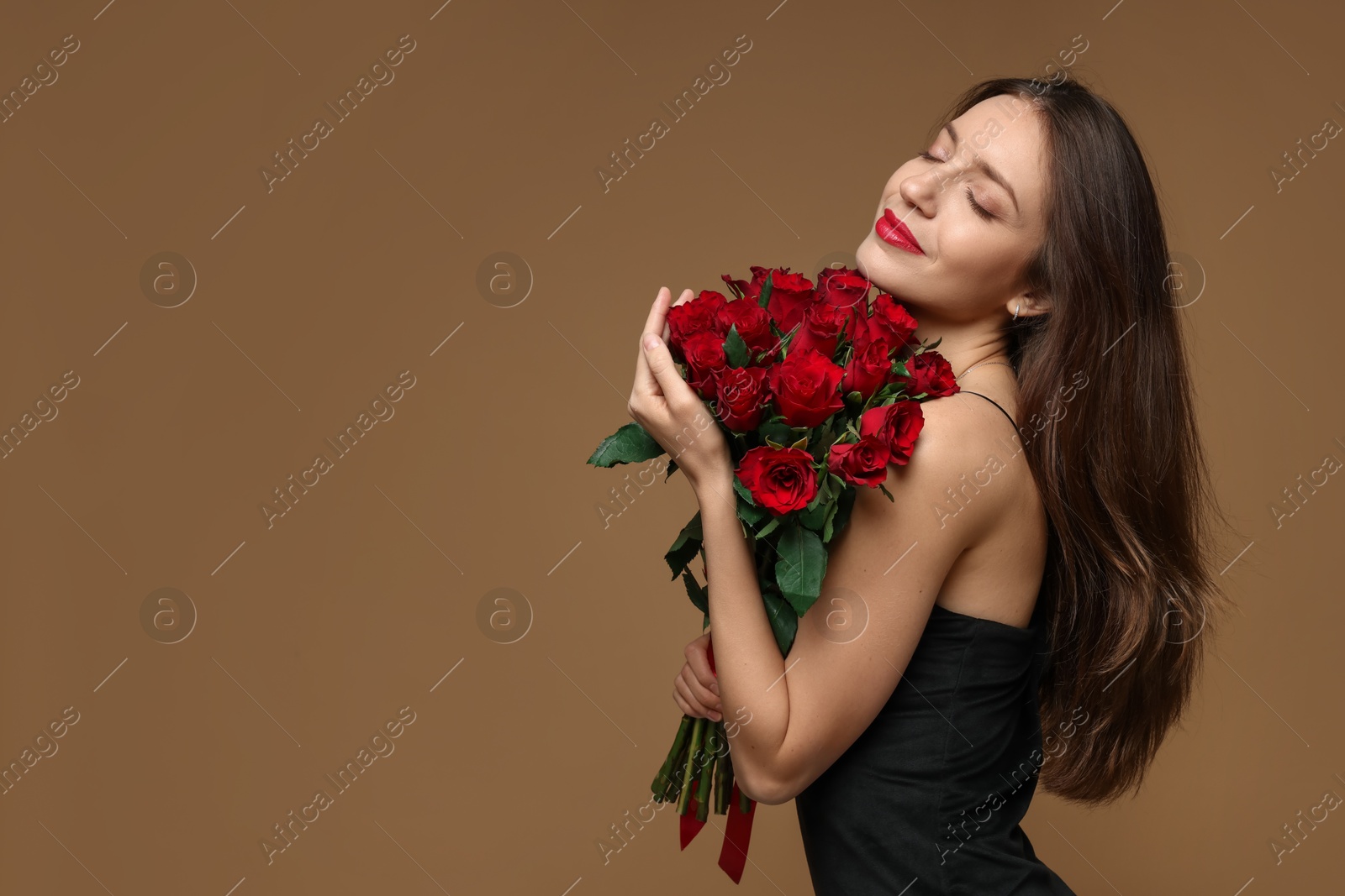 Photo of Happy Valentine's Day. Beautiful woman with bouquet of roses on brown background. Space for text