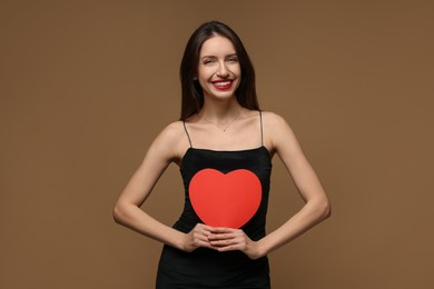 Photo of Happy Valentine's Day. Beautiful woman with paper heart on brown background