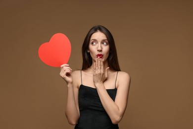 Photo of Happy Valentine's Day. Beautiful woman with paper heart on brown background