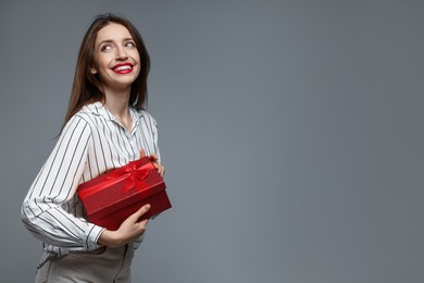 Photo of Happy Valentine's Day. Beautiful woman with gift on grey background. Space for text