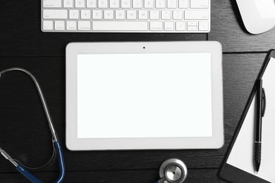 Photo of Cardiology. Flat lay composition with stethoscope and tablet on black wooden table