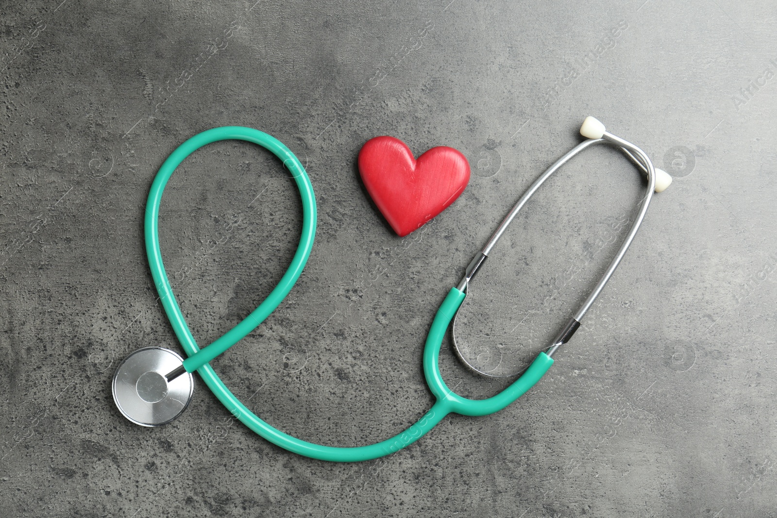 Photo of Cardiology. Stethoscope and red decorative heart on gray textured background, flat lay