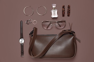 Image of Stylish jewelry, accessories and perfume on mocha mousse shade background, flat lay. Trendy color of 2025 year