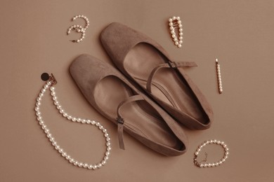 Image of Shoes in mocha mousse shade and stylish accessories on dark beige background, flat lay. Trendy color of 2025 year