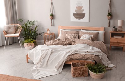 Image of Large bed with bedclothes in mocha mousse shade indoors. Stylish bedroom interior with trendy color of 2025 year