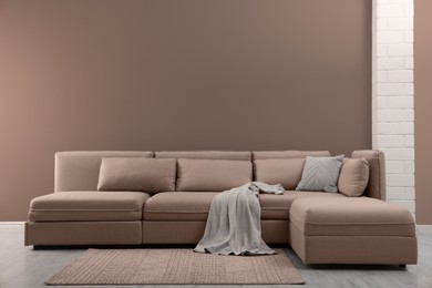 Image of Stylish interior in mocha mousse shade. Large sofa and wall in trendy color of 2025 year