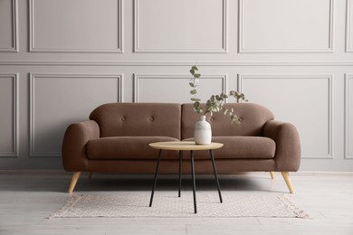 Image of Sofa in mocha mousse shade and table indoors. Interior with trendy color of 2025 year