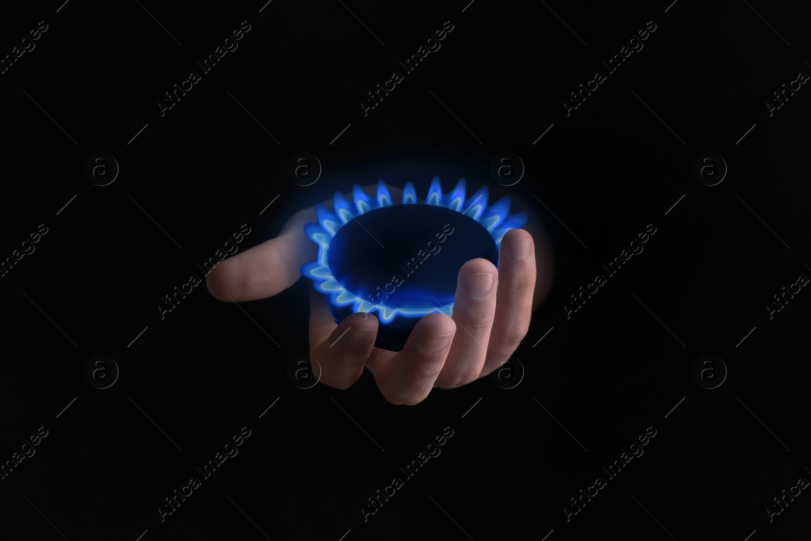 Image of Woman holding gas burner with blue flame on black background, closeup