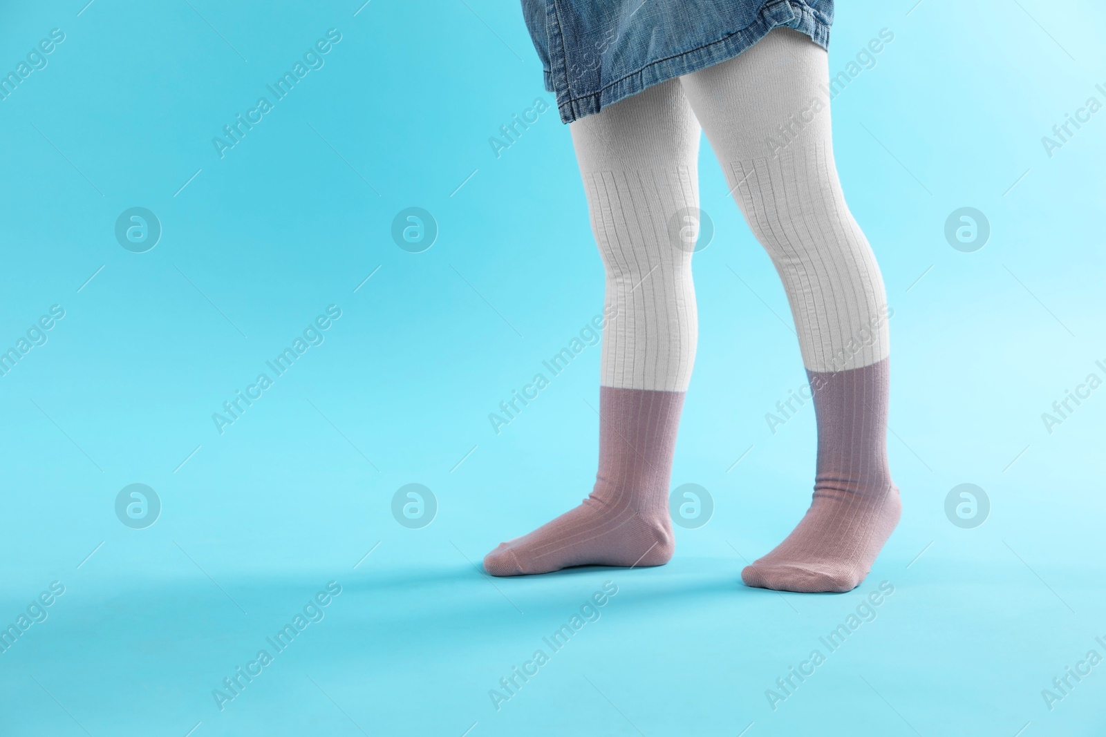 Photo of Child wearing tights on light blue background, closeup. Space for text