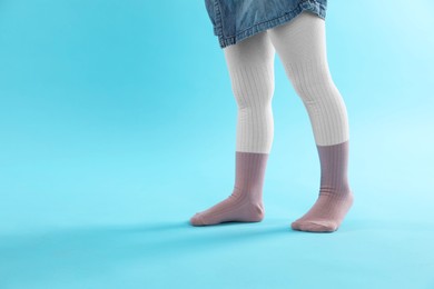 Photo of Child wearing tights on light blue background, closeup. Space for text