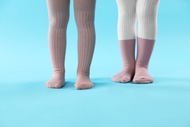 Photo of Kids wearing tights on light blue background, closeup