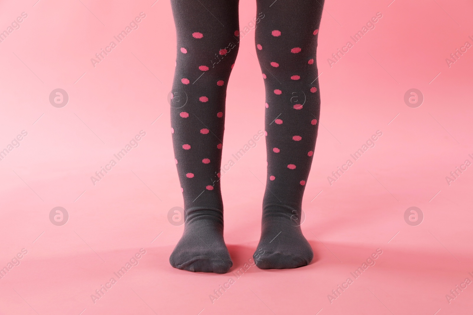 Photo of Child wearing tights on pink background, closeup