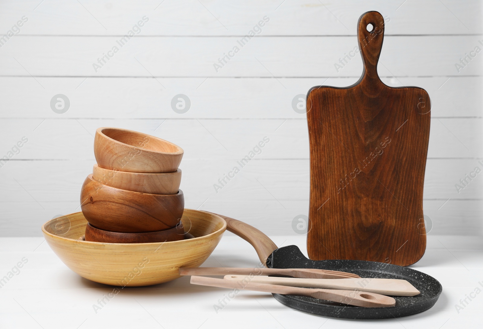 Photo of Dishware and cooking utensils on white table